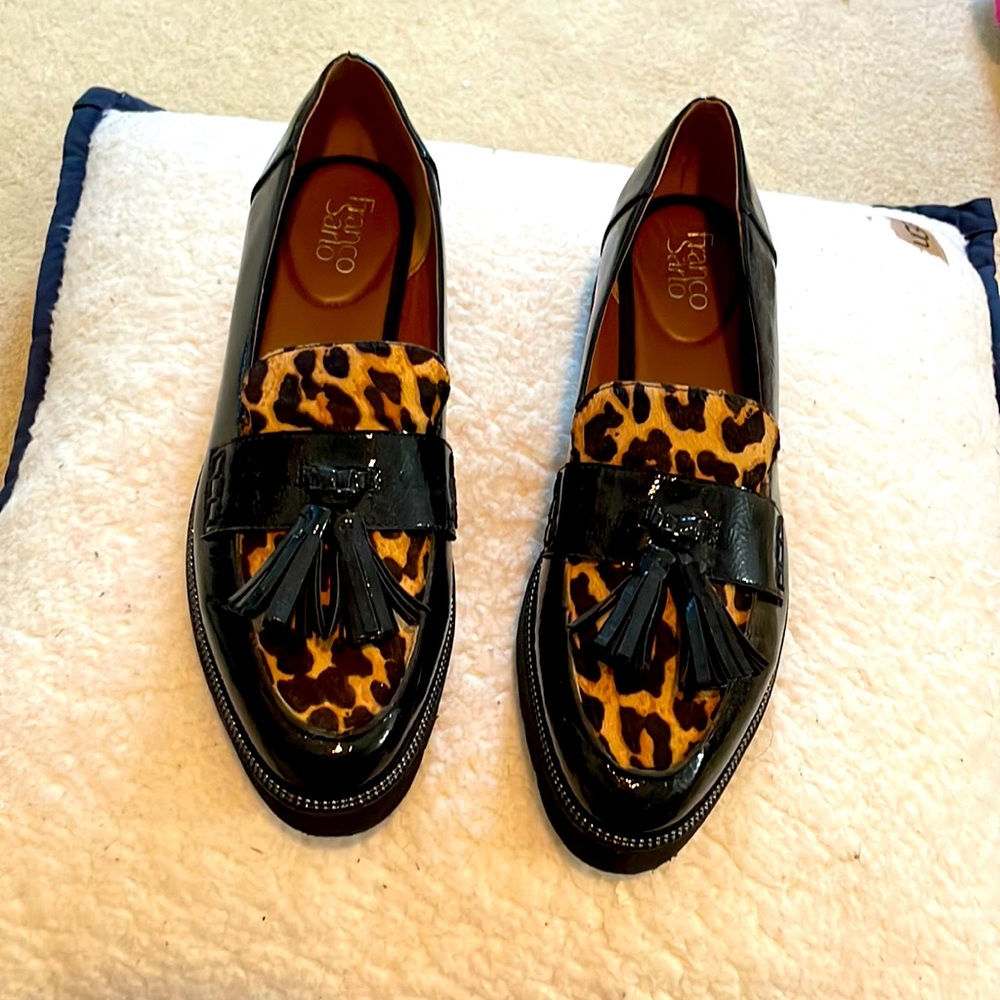 Black slip on elevator shoes with textured animal print and tassels.